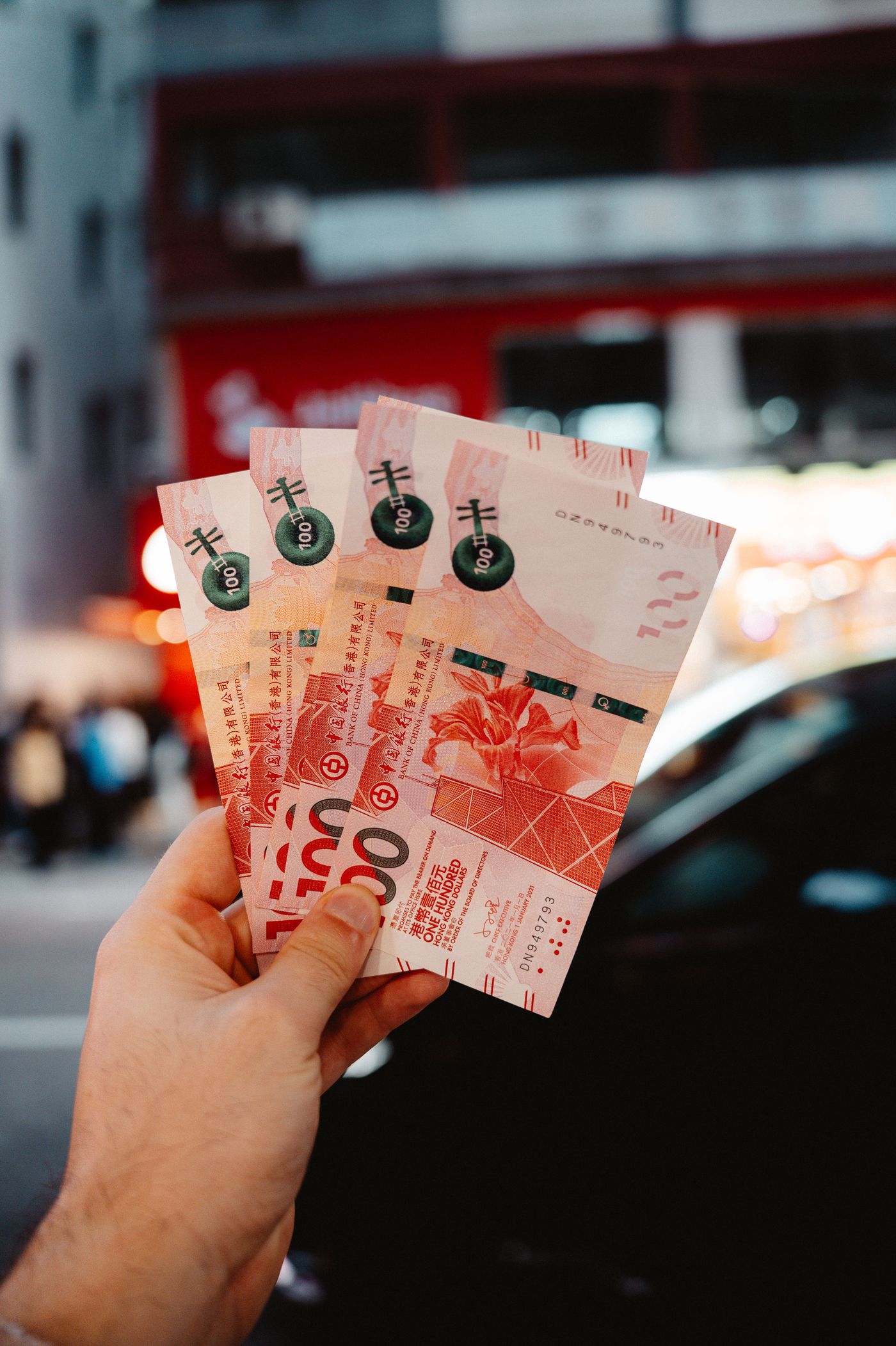手持港元紙幣,背景為香港街道